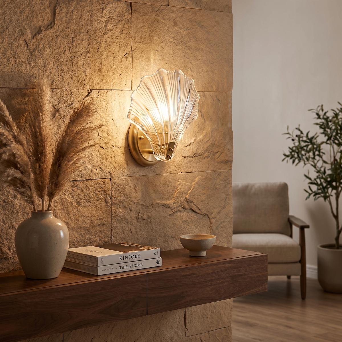 Clear Shell Glass Wall Sconce glowing above a timber console