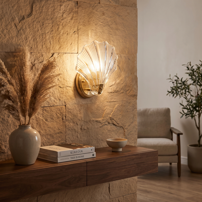 Clear Shell Glass Wall Sconce glowing above a timber console