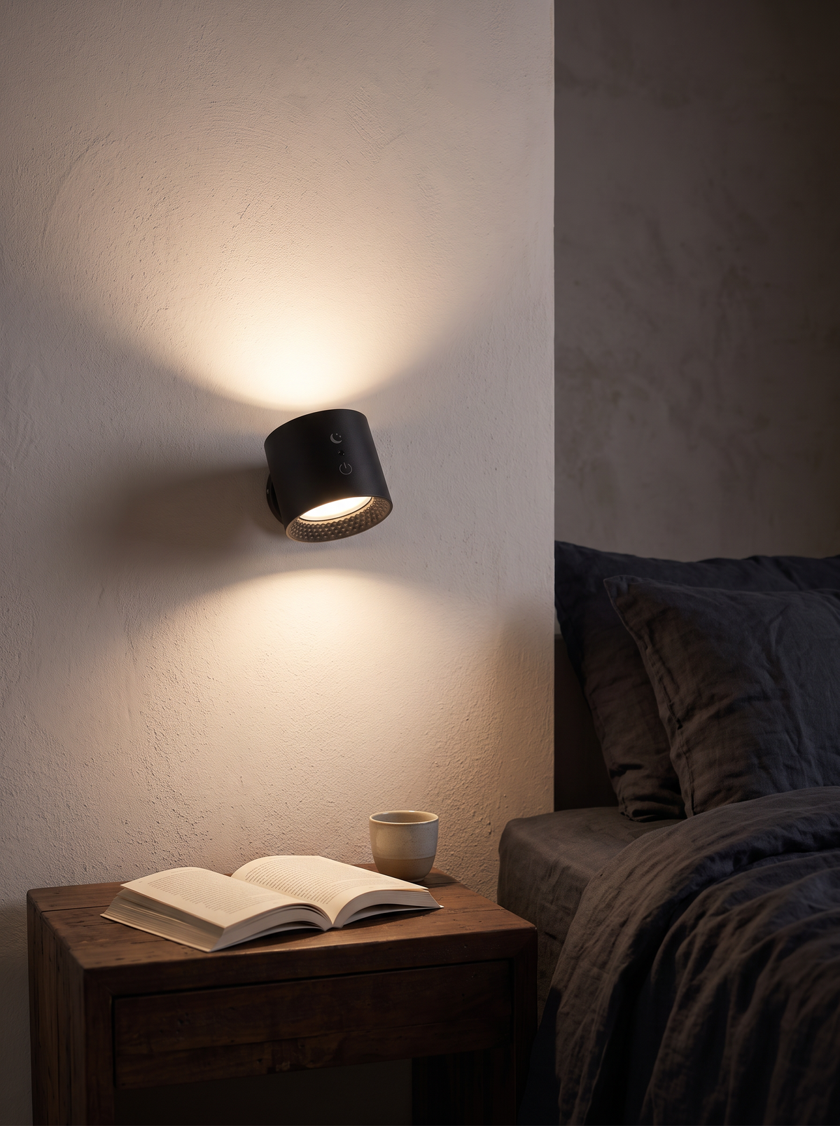 Cordless rechargeable wall light mounted above a bedside table, lighting an open book